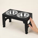 Elevated dog bowl stand next to a hand for size reference