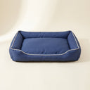 Blue waterproof square dog bed on a cream background