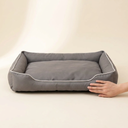 Waterproof square dog bed next to a hand for size reference