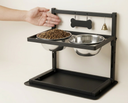 Wall-mounted dog bowl rack next to a hand for size reference