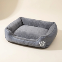 Grey square dog and cat bed cushion on a cream background