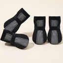 Black breathable mesh dog boots with reflective straps for dogs, studio photo