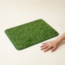 Grass pee pad next to a hand for size reference