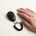 Black dog training clicker with adjustable wrist strap, scale photo
