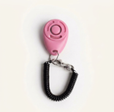 Pink dog training clicker with adjustable wrist strap, studio photo