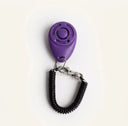 Purple dog training clicker with adjustable wrist strap, studio photo