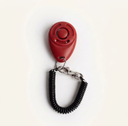 Red dog training clicker with adjustable wrist strap, studio photo