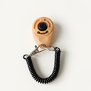 Tan dog training clicker with adjustable wrist strap, studio photo