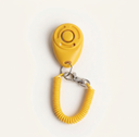 Yellow dog training clicker with adjustable wrist strap, studio photo