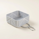 Grey collapsible dog travel bowl on a cream background