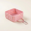 Pink collapsible dog travel bowl on a cream background