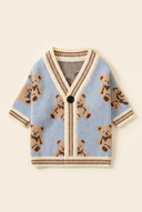 Blue knitted dog cardigan on a cream background