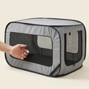Foldable mesh travel crate next to a hand for size reference